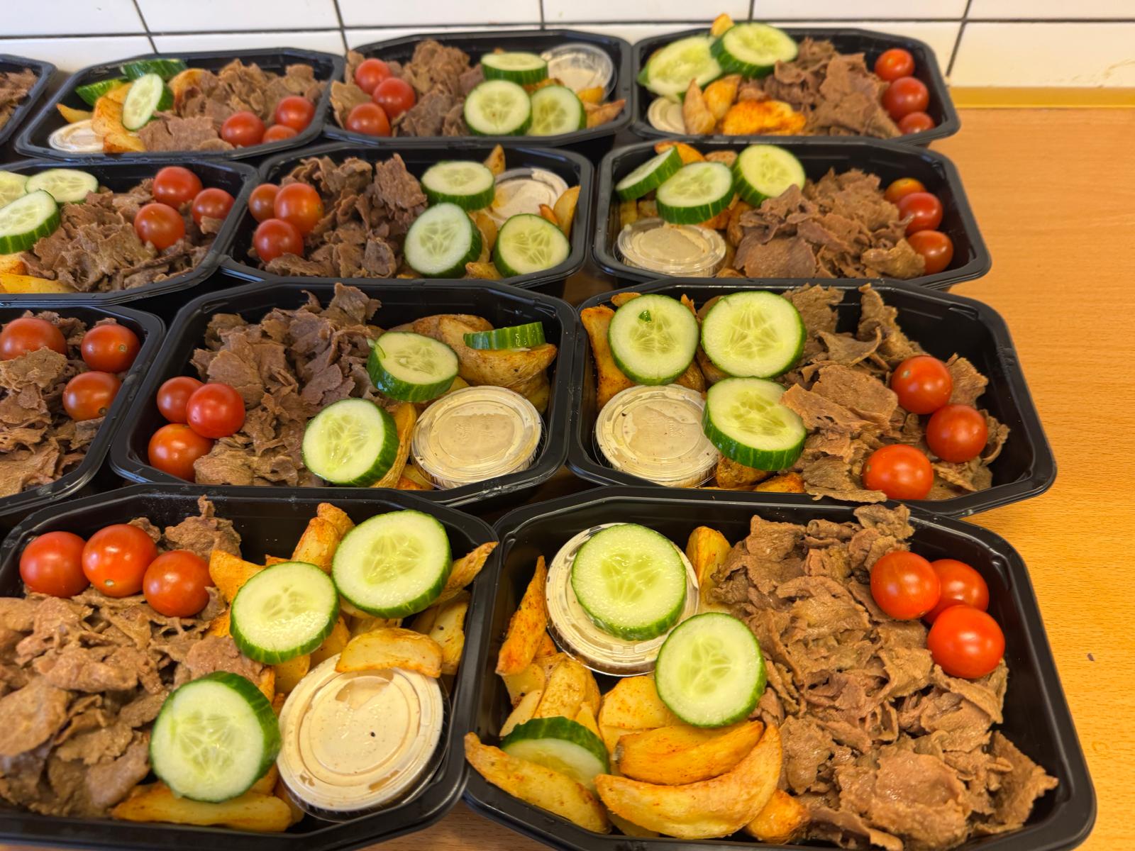 Rader av kebablådor med klyftpotatis, gurka och tomat