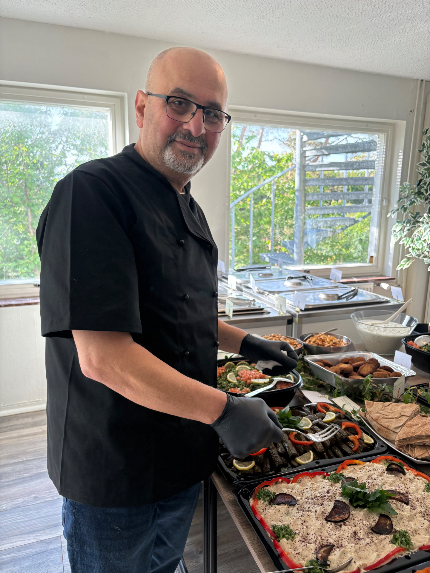 Kock som serverar libanesisk cateringbuffé