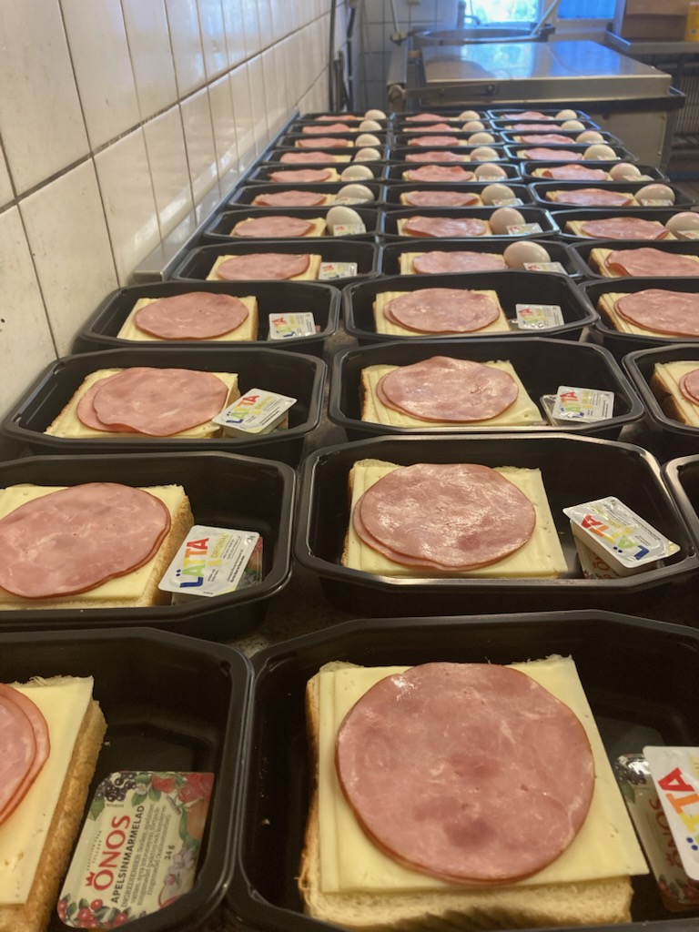 Långa rader frukostlådor med smörgås, ägg och pålägg
